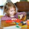 Little preschooler girl cutting paper