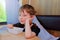 little preschooler sits in the stroller compartment by the window. He looks into the frame, in front of him is a plate