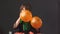 Little pretty girl in a beautiful dress inflating balloons orange color in turn with her mouth holding in her hands for