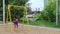 Little pretty girl in gumboots on swing at playground