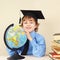 Little professor in academic hat with globe among old books