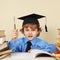 Little professor in academic hat with rarity pen among old books