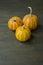 Little pumpkins. Decorative pumpkin on the table. Halloween. View from the side. Dark background