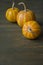 Little pumpkins. Decorative pumpkin on the table. Halloween. View from the side. Dark background