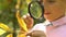 Little pupil learning structure of yellow leaf with magnifying glass, close up