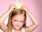 Little queen child girl with gold crown. Little princess in yellow crown on pink background. Cute child face expressing