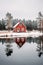 Little red cabin in the woods on a reflective lake. Lone house reflection in the winter forest.