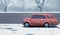 Little red car drives fast over the icy road