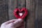 Little red clothespins hearts in hand on a background of a big heart. Love