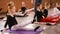 Little red-haired girl ballerina stretching and doing exercises in ballet school