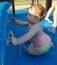 Little red headed girl playing in water at sprinkler park