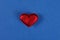 little red heart made of matter lies on a blue table