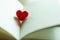 Little red heart in a opened page of literature