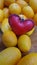 Little red heart on yellow fresh small oranges on wooden floor