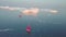 Little red sailboat cruising among floating icebergs in Disko Bay glacier during midnight sun season of polar summer. Ilulissat,