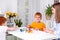 Little redhead boys with a nanny or mother or teacher sit at the table and paint with colors