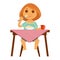 Little redhead girl sits at table and has breakfast