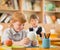 Little redhead schoolboy behind desk