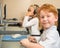 Little redhead schoolboy in front of desktop computer