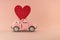 Little retro toy model car with red heart on pastel pink background. Love, friendship, valentines day, delivery