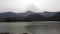 The little river flows over forest and mountain on the background in sunset soft light