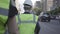 Little road worker or inspector wearing safety equipment and constructor helmet walking with unrecognized assistant