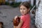 Little rural girl with chicken in her arms