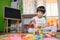 Little sad thoughtful bored toddler boy playing colorful building blocks alone at home during quarantine. development game.