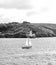 little sailing boat in front of falmouth light house