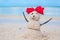 Little sandy snowman with bow on a sandy Caribbean