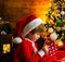 Little Santa Claus helper elf with a magic gift for Christmas. Family holiday. Merry christmas and happy new year. Check