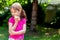 Little school age girl, young child eating, biting a single slice of bread with butter, copy space, outdoors portrait, lifestyle