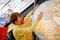 Little school boy with huge planet earth globe. Child, student with backpack and medical mask at school. Education