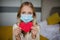 Little school kid girl holding red heart. Valentine& x27;s day during pandemic coronavirus covid-19 quarantine. Child showing