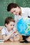 Little schoolboy looks at the terrestrial globe