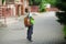 Little schoolboy stand on a schoolyard.