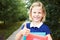 Little schoolgirl holds in hands books and smiling.