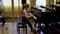 A little schoolgirl plays a classical piece of music on a piano. Young talents.