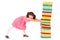 Little schoolgirl push a stack of heavy books