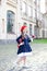 Little schoolgirl in a red beret and dress with lunch near the school. preschool child with an apple and a backpack on his first d