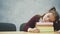 A little schoolgirl sleeps at the table with a lot of books. Many homework or examinations are stressful for young