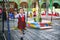 A little schoolgirl in uniform smiles happily after playing on the swing inside the school playground