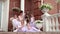 Little schoolgirls of ballet school sit on a porch of school. Lovely little schoolgirls train on a porch ladder opposite