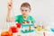 Little serious boy in safety glasses doing chemical experiments in laboratory