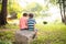 Little sibling boy sitting together in the park outdoor