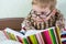 Little sick boy reading book in bed