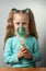 Little sick girl breathes through nebulizer, on gray background