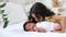 little sister kissing or playing with a newborn black african American baby, black brother and sister close-up lying on