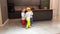 Little sister triplets in dog costumes playing and jumping in the kitchen of their house