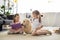 little sisters with books and golden retriever dog near by sitting on floor